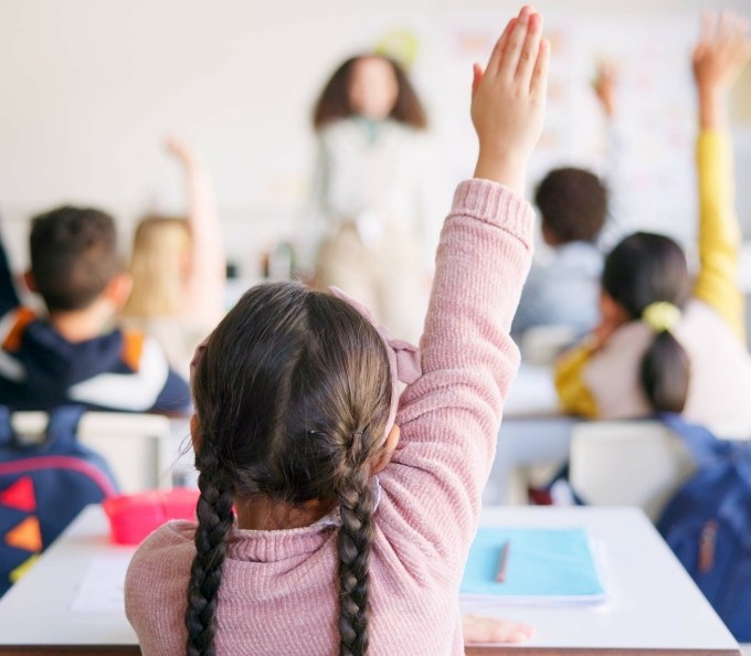 Girl in classroom raising her hand