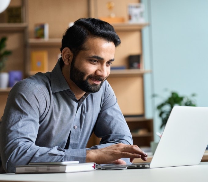 Man sitting at desk and using laptop