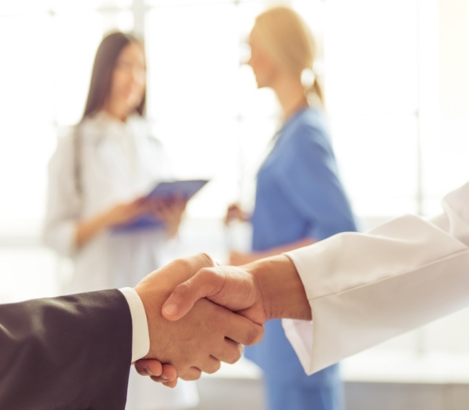 Two medical professionals shaking hands