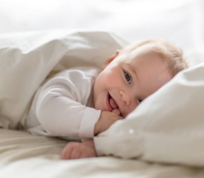 Smiling baby laying down after lip and tongue tie treatment in Southampton