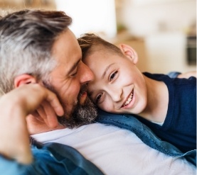 Young boy resting his head on his fathers shoulder