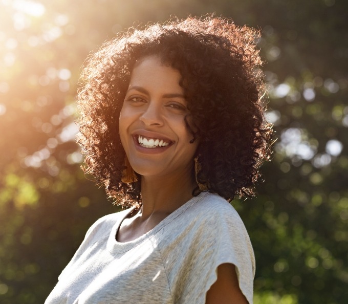 Adult woman smiling with trees in background